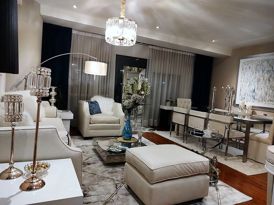 Sala clásica con sillón capitonado, otomana y candelabro