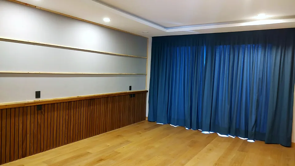 Recámara con muro tapizado, lambrín de madera y cortinas azules hecha por Velvet