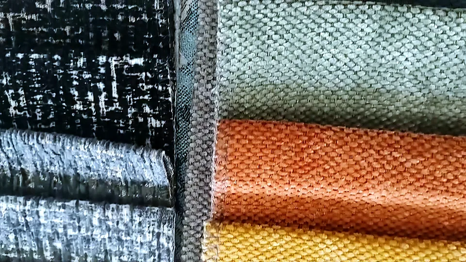 Muestras de telas jacquard y chenille en negro, gris, naranja y mostaza